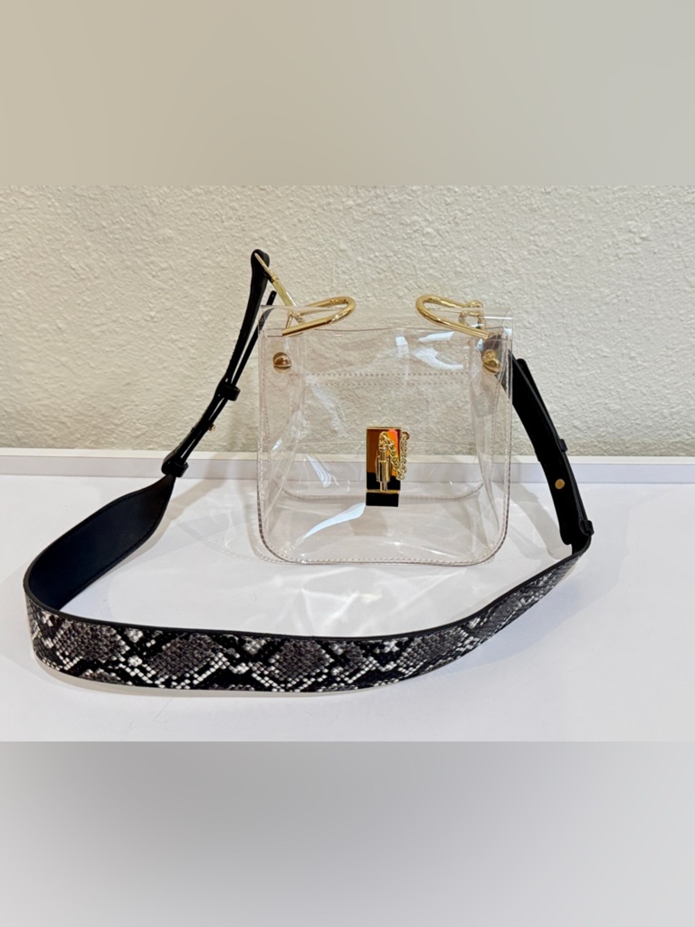 Transparent Crossbody Bag with Gold Accents and Black Snakeskin Strap